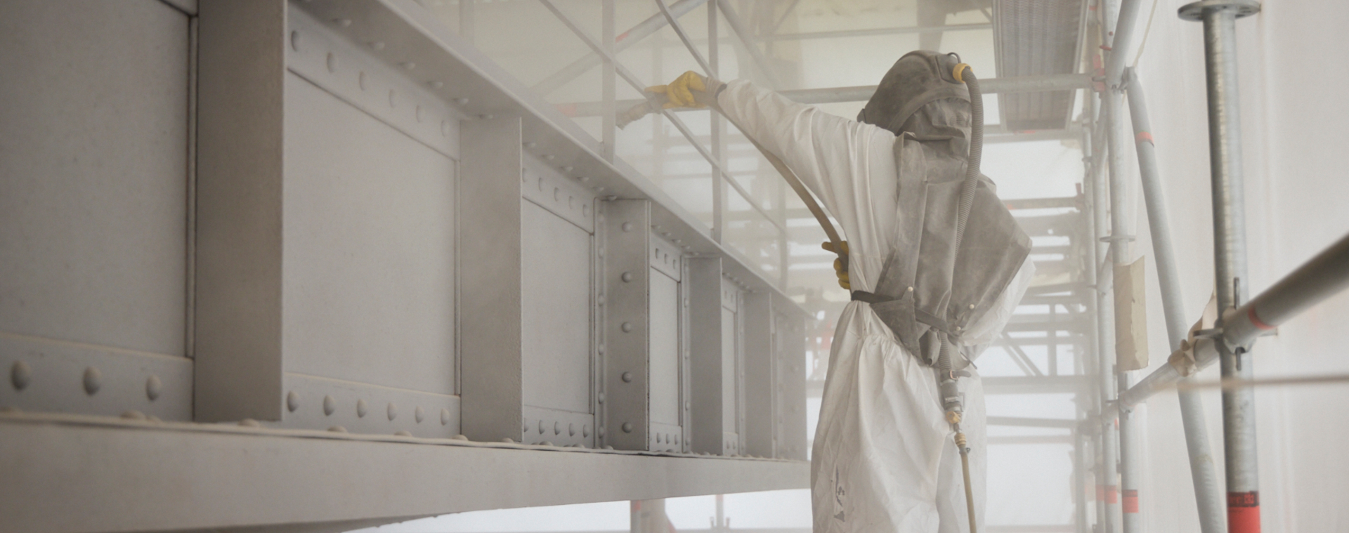 Workers in protective suits refurbish winding tower